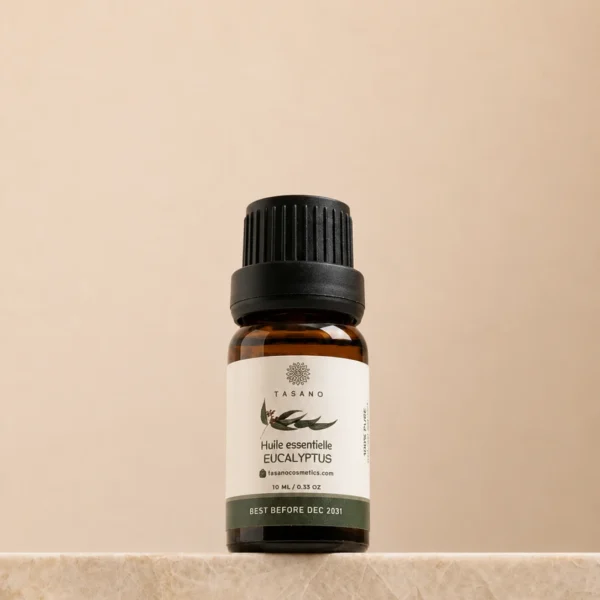 TASANO Eucalyptus Essential Oil 10 ml bottle on beige marble pedestal, Moroccan aromatherapy oil in amber glass.