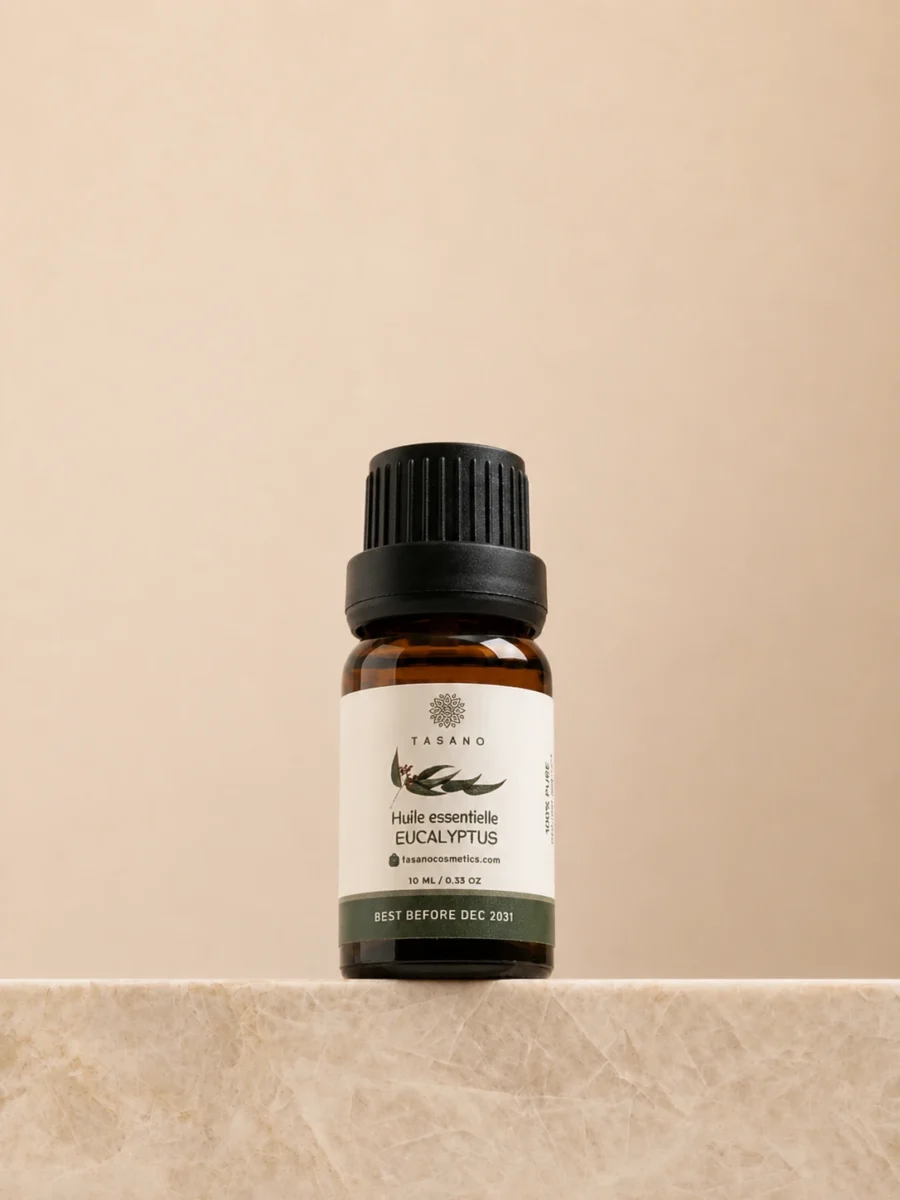 TASANO Eucalyptus Essential Oil 10 ml bottle on beige marble pedestal, Moroccan aromatherapy oil in amber glass.