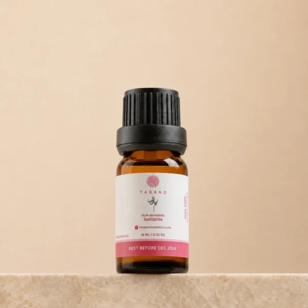 TASANO Gardenia Essential Oil 10 ml bottle on beige marble pedestal, Moroccan aromatherapy oil in amber glass.