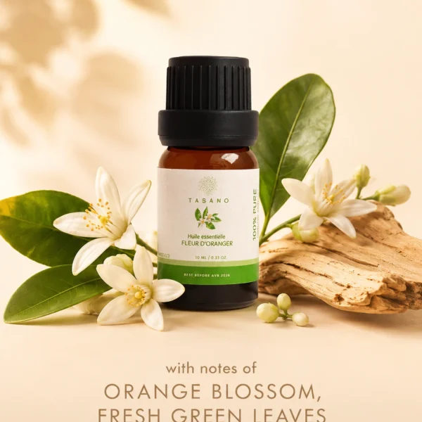 TASANO orange blossom essential oil bottle surrounded by orange blossom flowers in a fresh floral scent profile. TASANO orange blossom essential oil bottle surrounded by orange blossom flowers in a fresh floral scent profile.