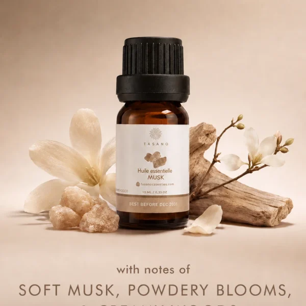 TASANO Musk essential oil bottle with soft musk stones, white florals and creamy woods on a warm neutral background showing its clean, comforting scent profile. TASANO Musk essential oil bottle with soft musk stones, white florals and creamy woods on a warm neutral background showing its clean, comforting scent profile.
