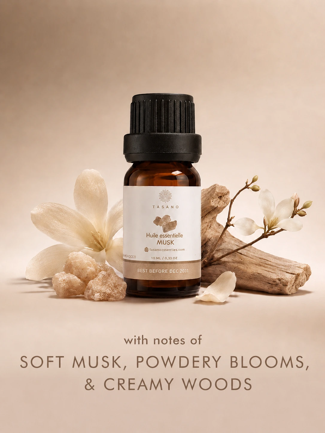 TASANO Musk essential oil bottle with soft musk stones, white florals and creamy woods on a warm neutral background showing its clean, comforting scent profile.