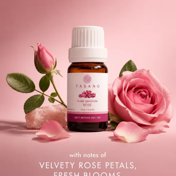 TASANO Rose essential oil bottle surrounded by rose petals and floral elements on a rose-toned background showing its delicate romantic scent profile. TASANO Rose essential oil bottle surrounded by rose petals and floral elements on a rose-toned background showing its delicate romantic scent profile.