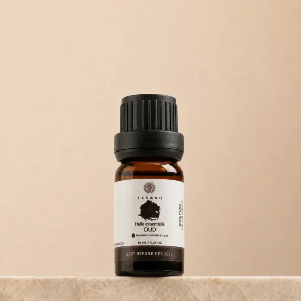 TASANO Oud Essential Oil 10 ml bottle on beige marble pedestal, Moroccan aromatherapy oil in amber glass.